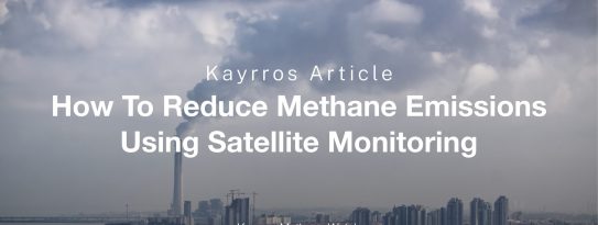 Facilities with smoke and gas emissions billowing from their smokestacks.